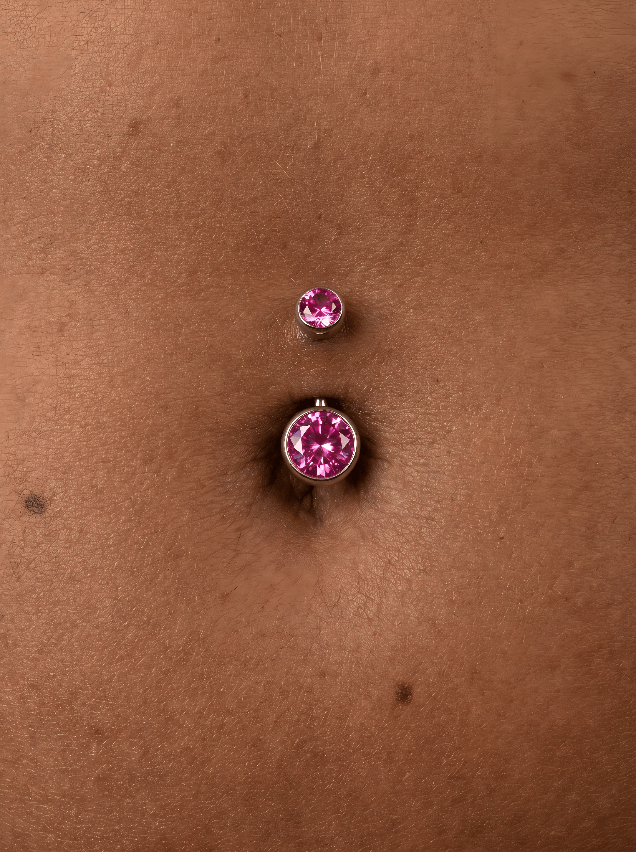 Un primer plano de un ombligo con el piercing «Titanio-Noble Art OMBLIGO CZ ROSA», que cuenta con dos piedras rosas, sobre piel morena.
