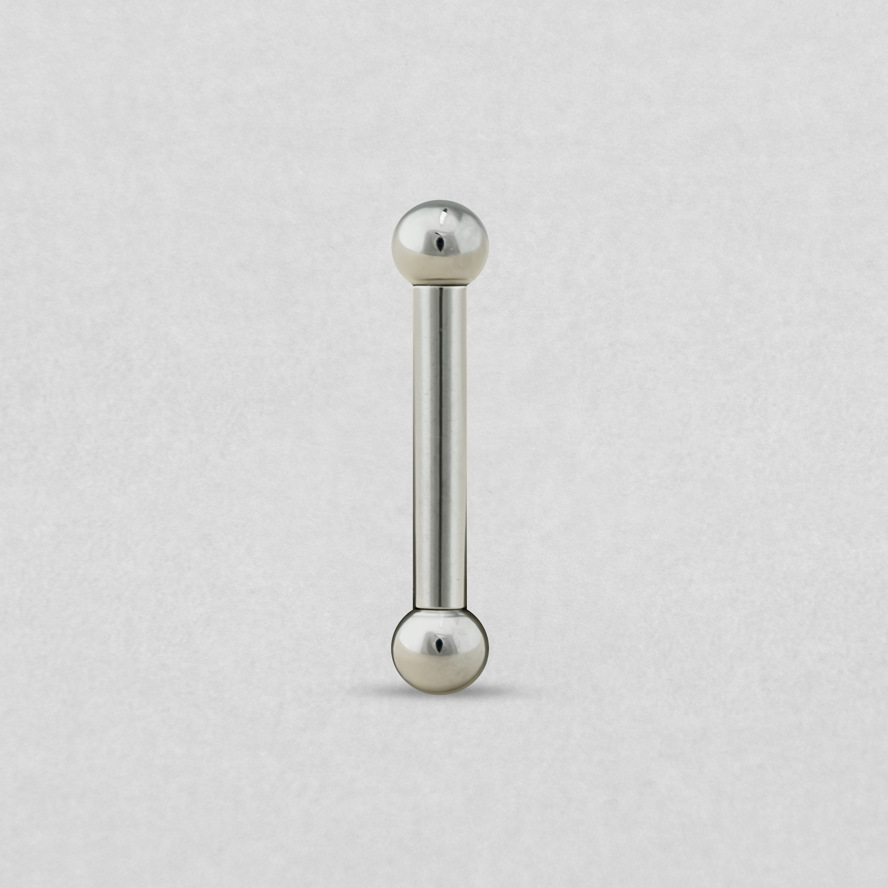 La BARBELL de NOBLE ART BEAUTY SOCIEDAD LIMITADA, con una estructura metálica y extremos esféricos, se muestra en posición vertical sobre un fondo gris claro.