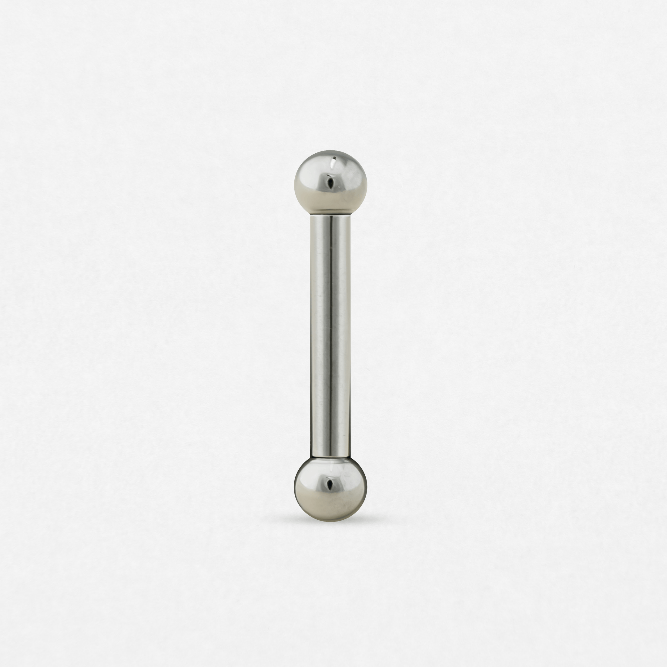 Una barra recta de Titanio-Noble Art con una bola en cada extremo, representada en posición vertical sobre un fondo blanco: ideal para resaltar tu piercing o combinarla con un nuevo tatuaje.