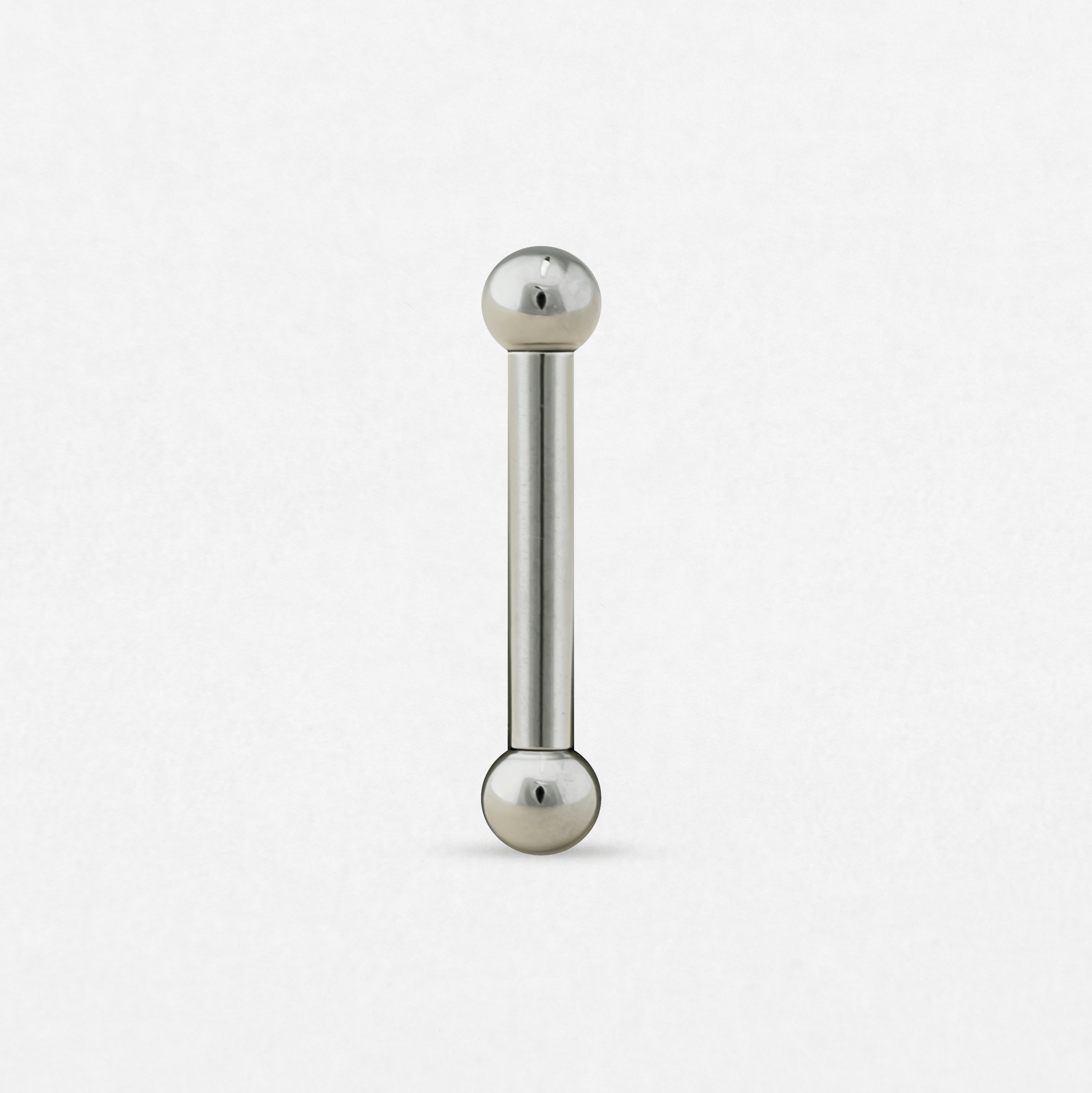 Una barra recta de Titanio-Noble Art con una bola en cada extremo, representada en posición vertical sobre un fondo blanco: ideal para resaltar tu piercing o combinarla con un nuevo tatuaje.
