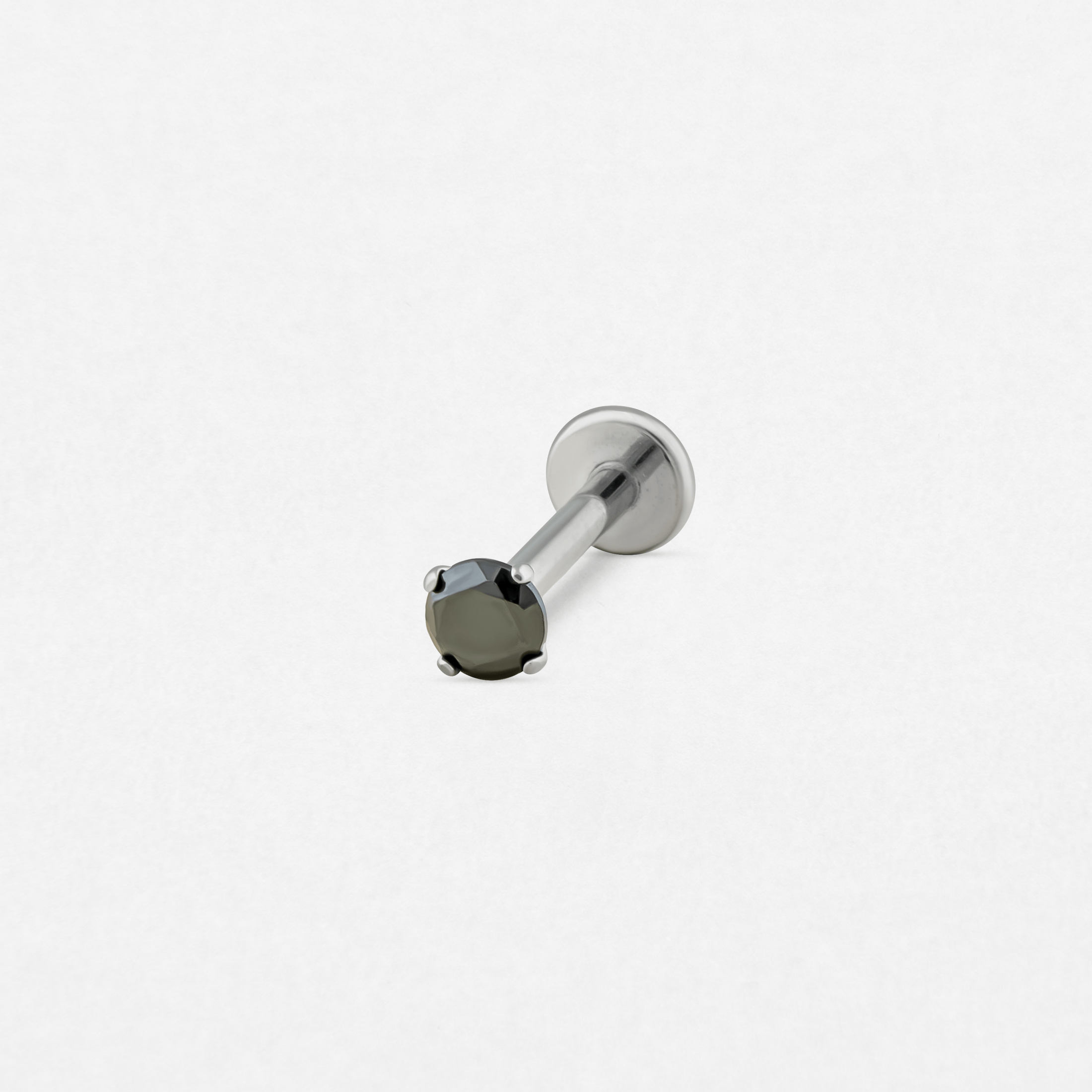 Un pendiente labret individual de color plateado, el «Circonita negra» de Titanio-Noble Art, cuenta con una gema redonda negra engastada con garras: una joya elegante ideal para llevar tras un tatuaje o una eliminación con láser en Noble Art.