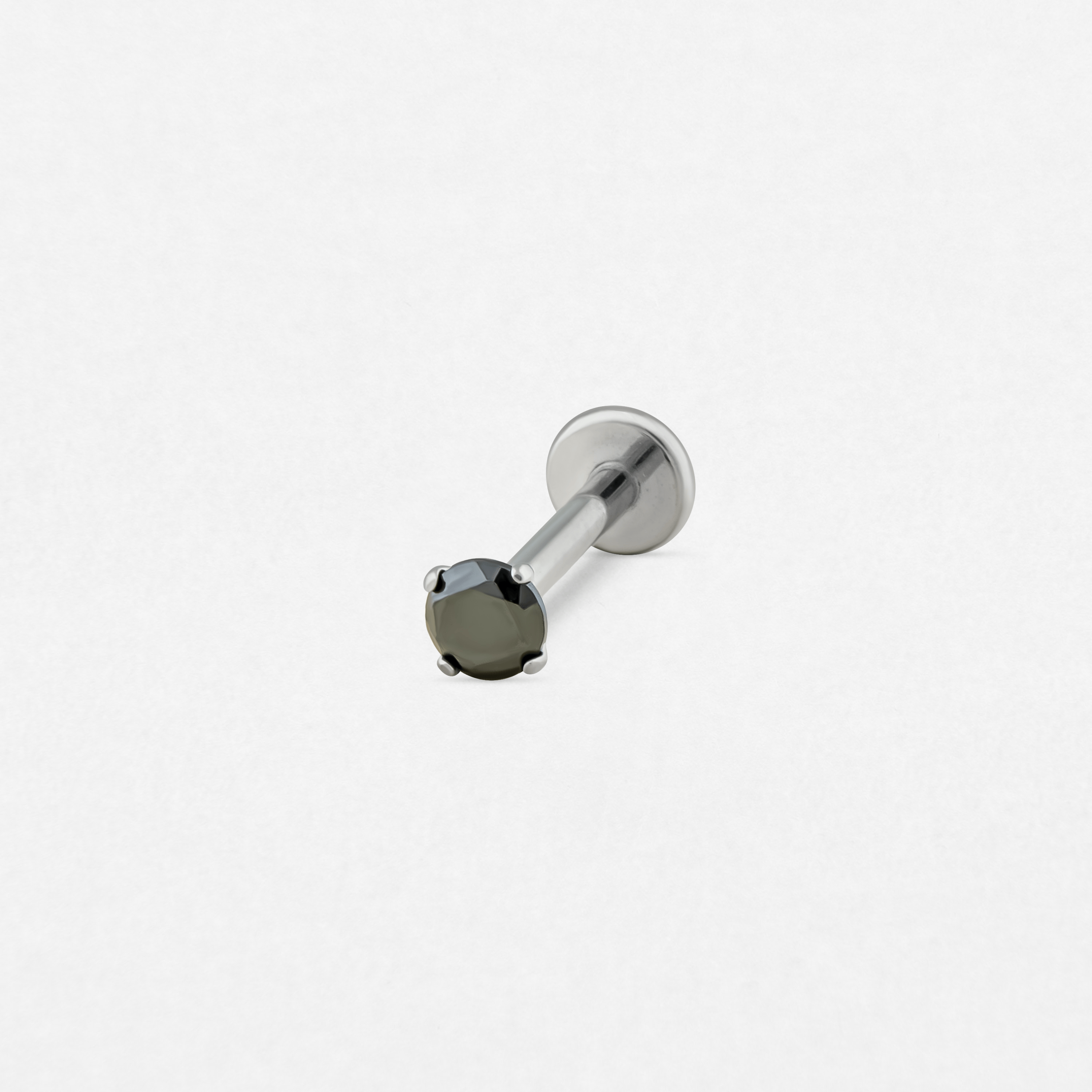 Un pendiente labret individual de color plateado, el «Circonita negra» de Titanio-Noble Art, cuenta con una gema redonda negra engastada con garras: una joya elegante ideal para llevar tras un tatuaje o una eliminación con láser en Noble Art.