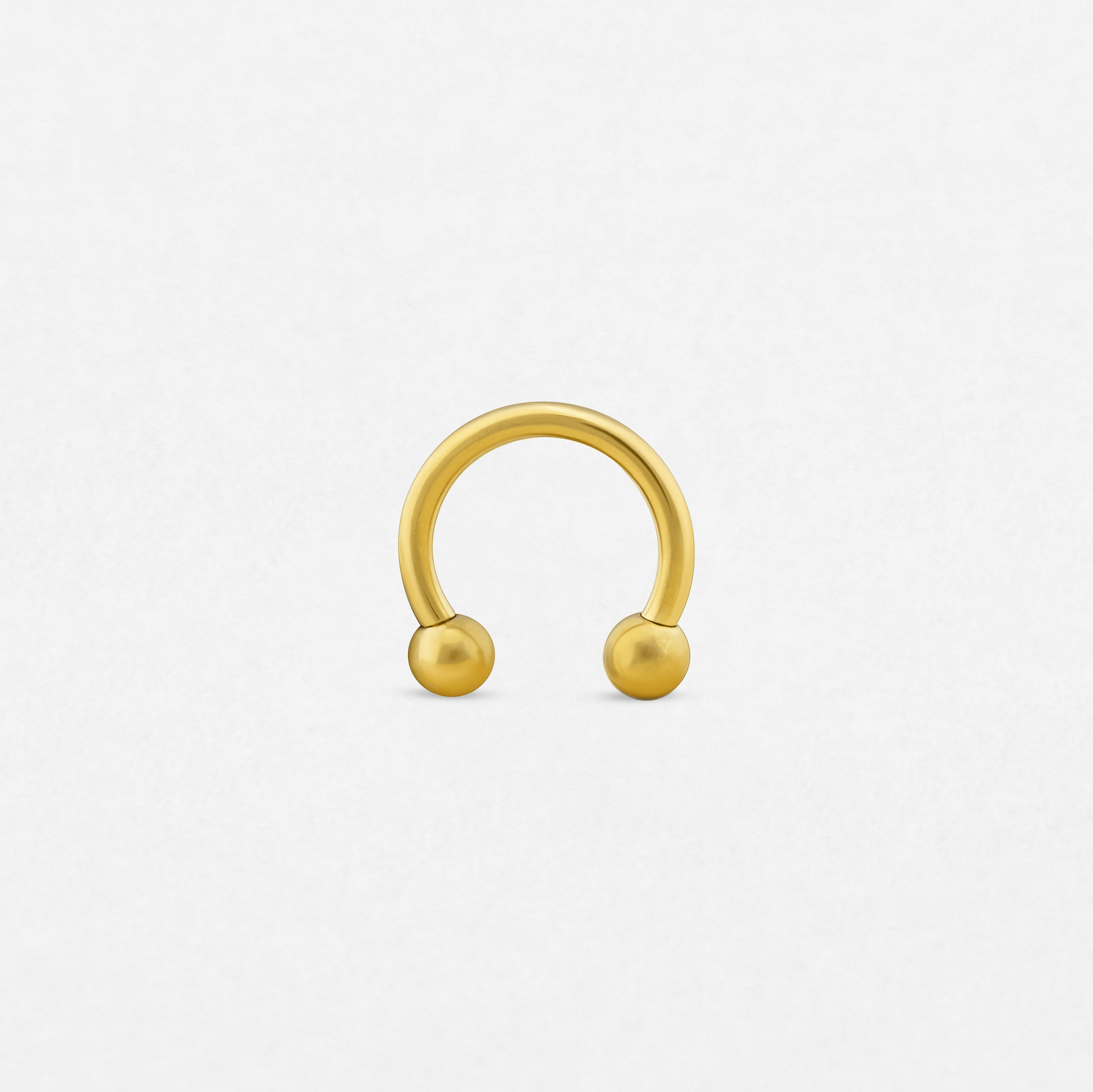 A Circular barbell with two round ball ends is displayed upright on a plain white background—ideal for those who value unique piercing styles from Noble Art Miami.