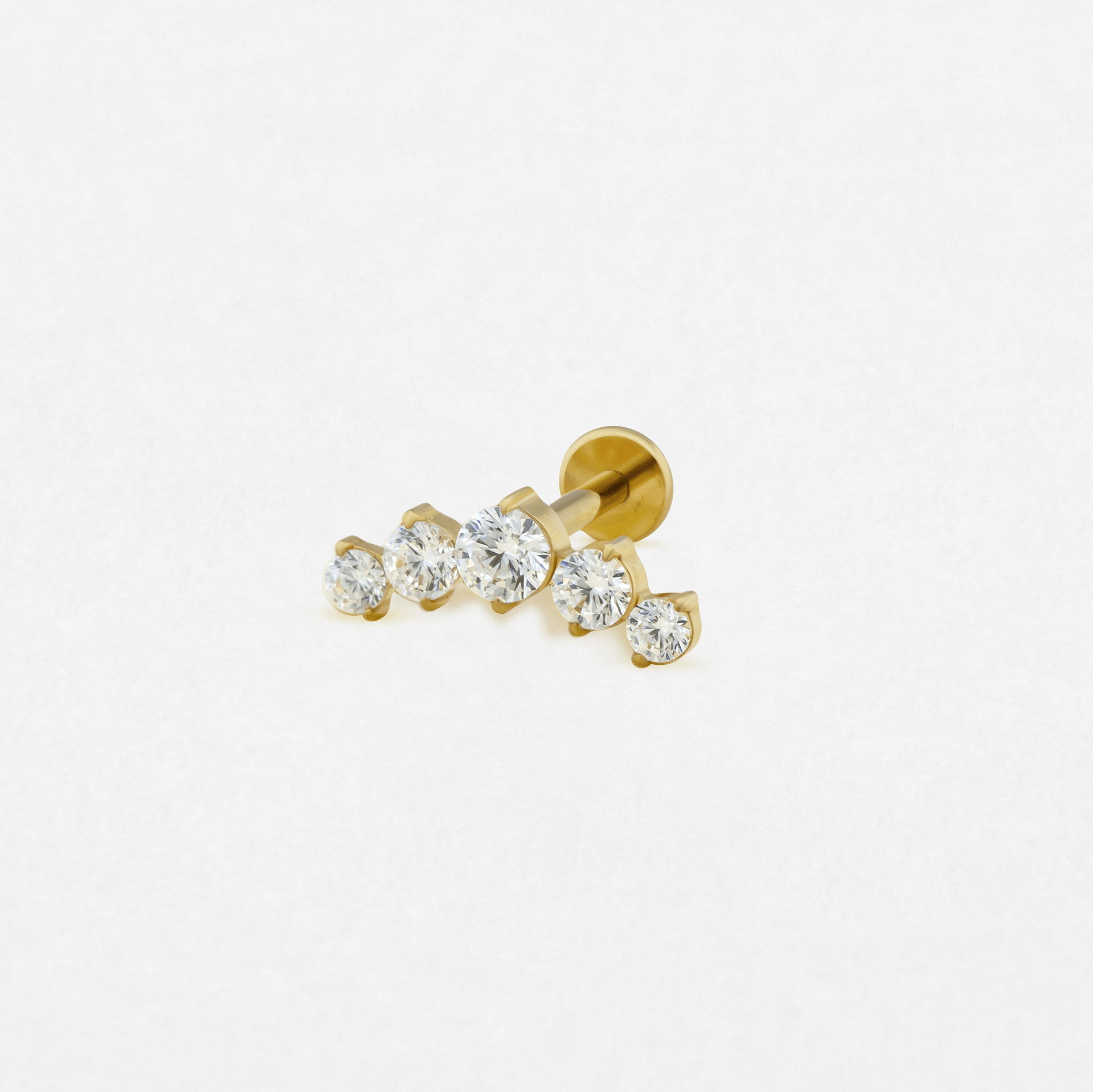 El pendiente de oro con engaste en forma de garra «Titanio-Noble Art Cluster» cuenta con cinco piedras redondas transparentes, dispuestas en una línea curva de menor a mayor tamaño, sobre un fondo blanco.