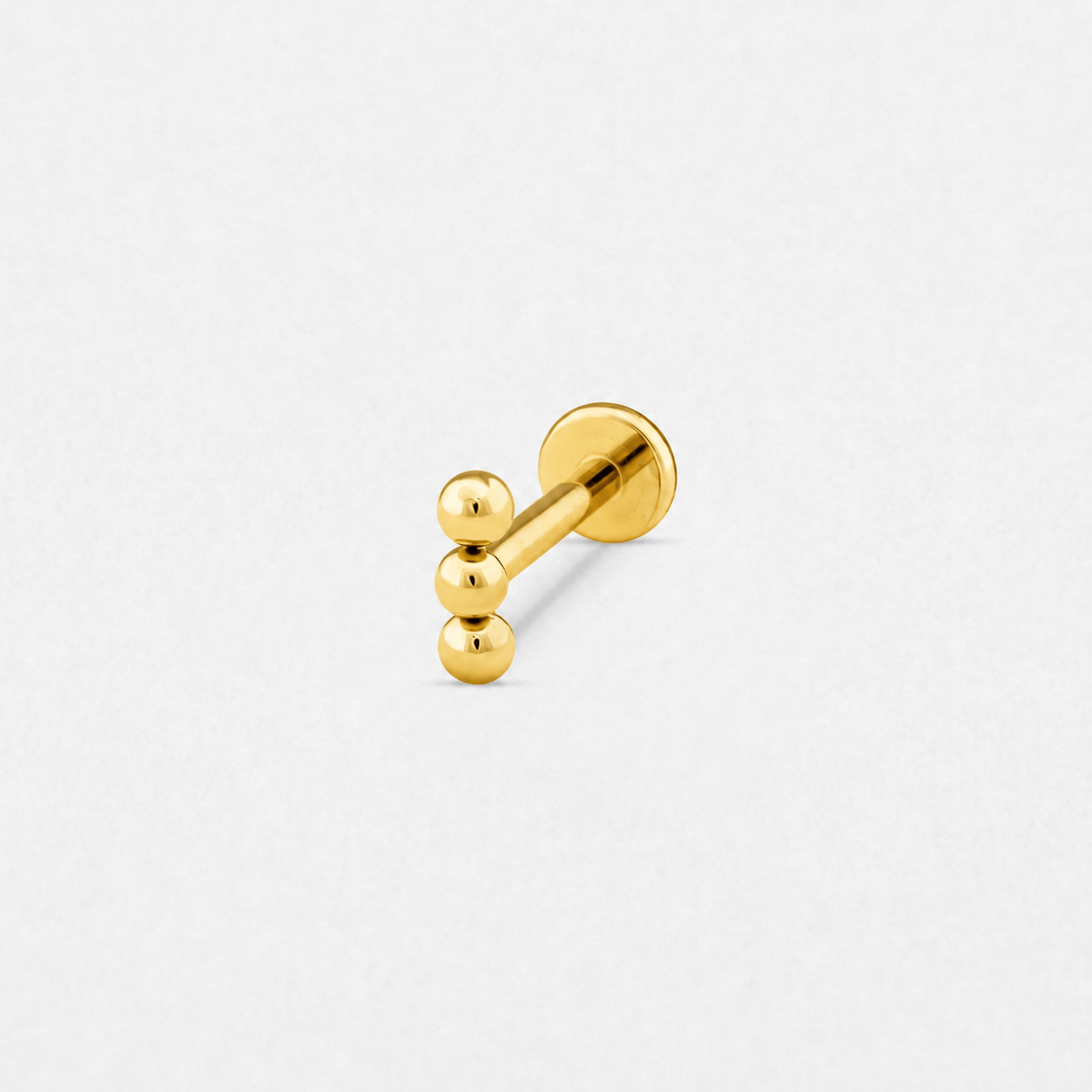 El pendiente labret de plata «Fenix» de Titanio-Noble Art presenta tres pequeñas cuentas de plata dispuestas verticalmente en un extremo, ideal para los amantes de los piercings que aprecian el diseño refinado, y se muestra sobre un fondo blanco liso.