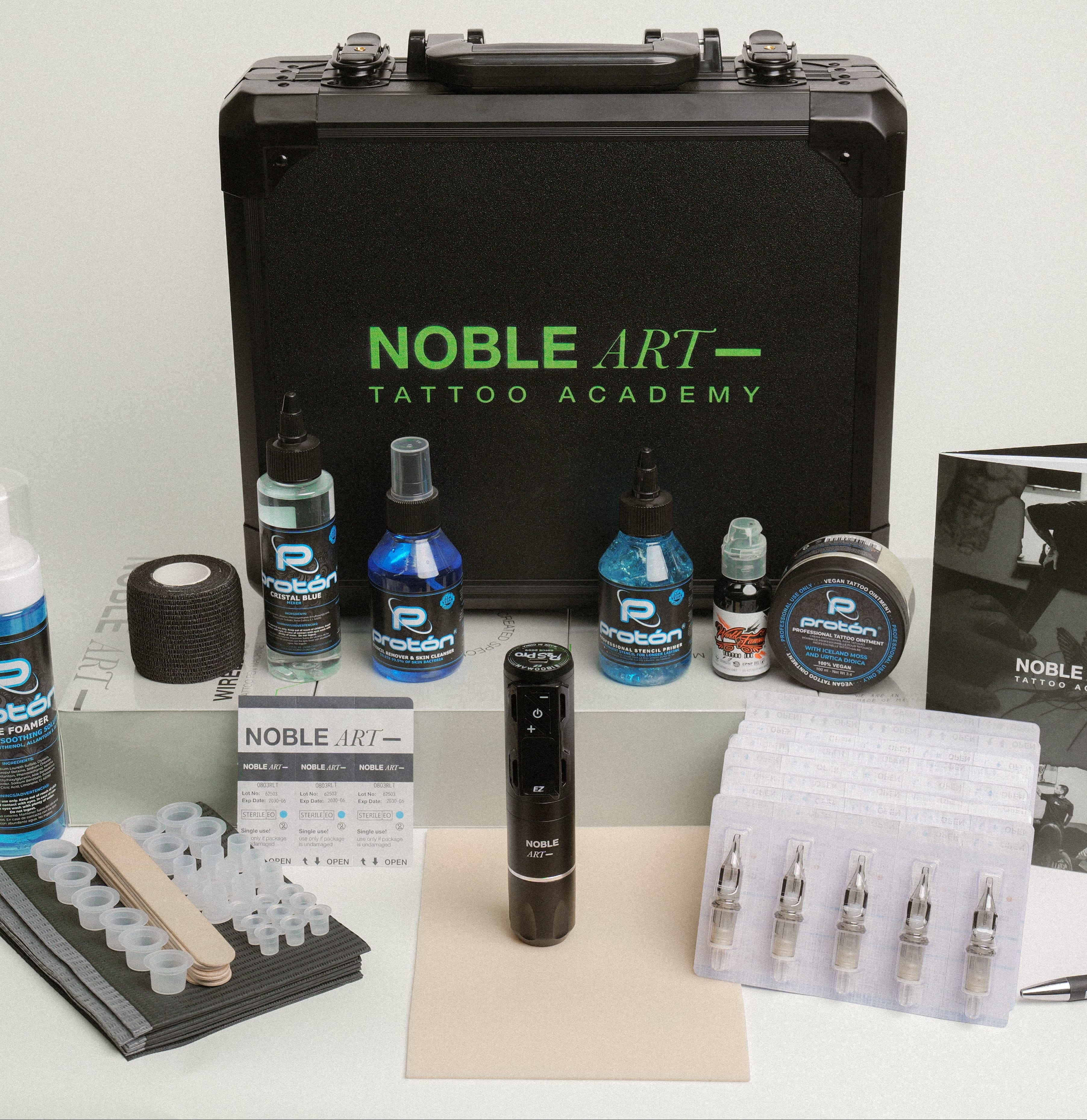 El Kit de tatuaje para principiantes incluye un estuche negro Noble Art Tattoo Academy, tintas, agujas cartucho, botellas de spray, grip tape, vasos para tinta, manuales e máquina central—ideal para artistas de tatuaje y piercing en Miami.