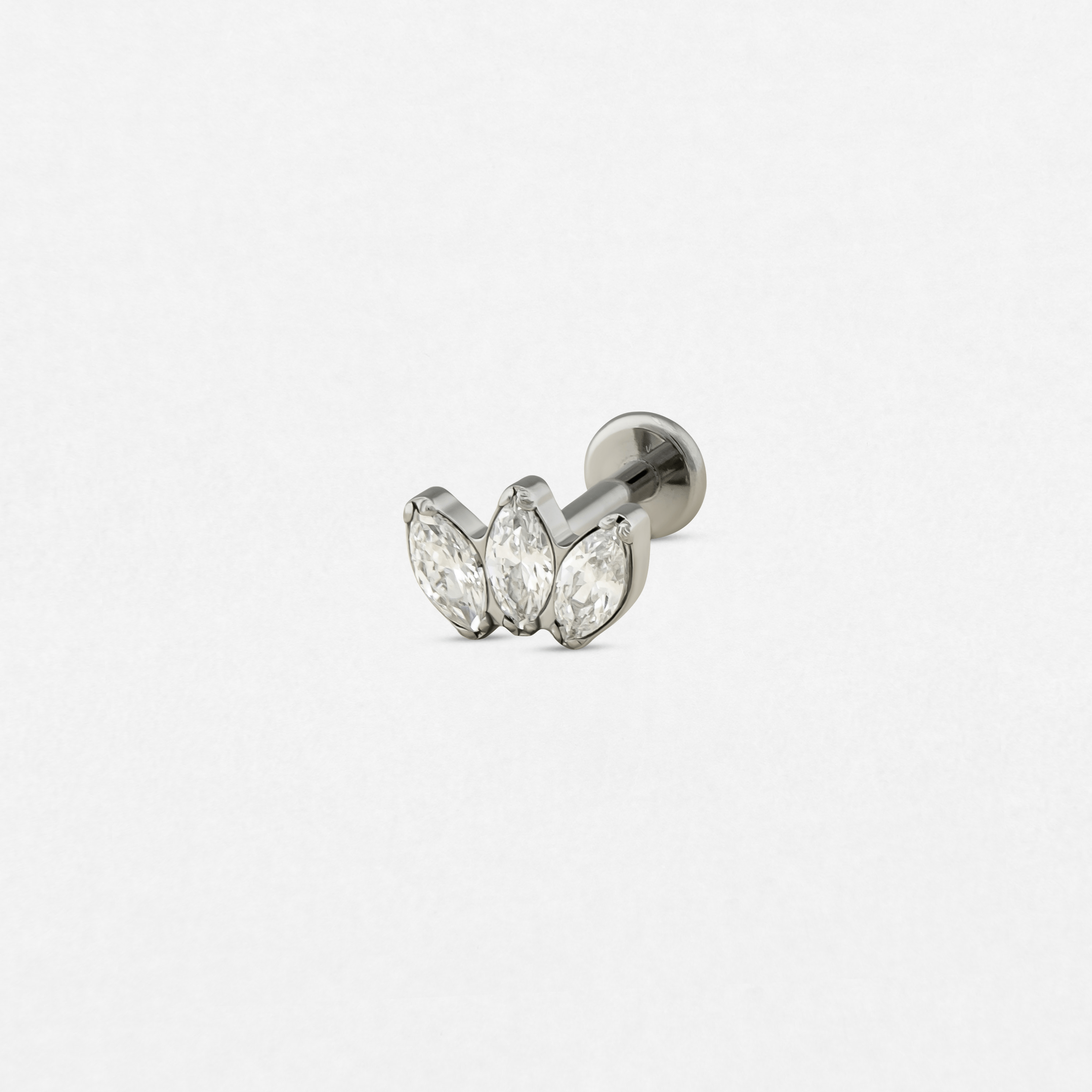 El pendiente «Marquise 3 CZ» de Titanio - Noble Art presenta tres piedras transparentes de talla marquesa dispuestas en fila, perfectas para cualquier tipo de piercing, y se muestra sobre un fondo blanco.