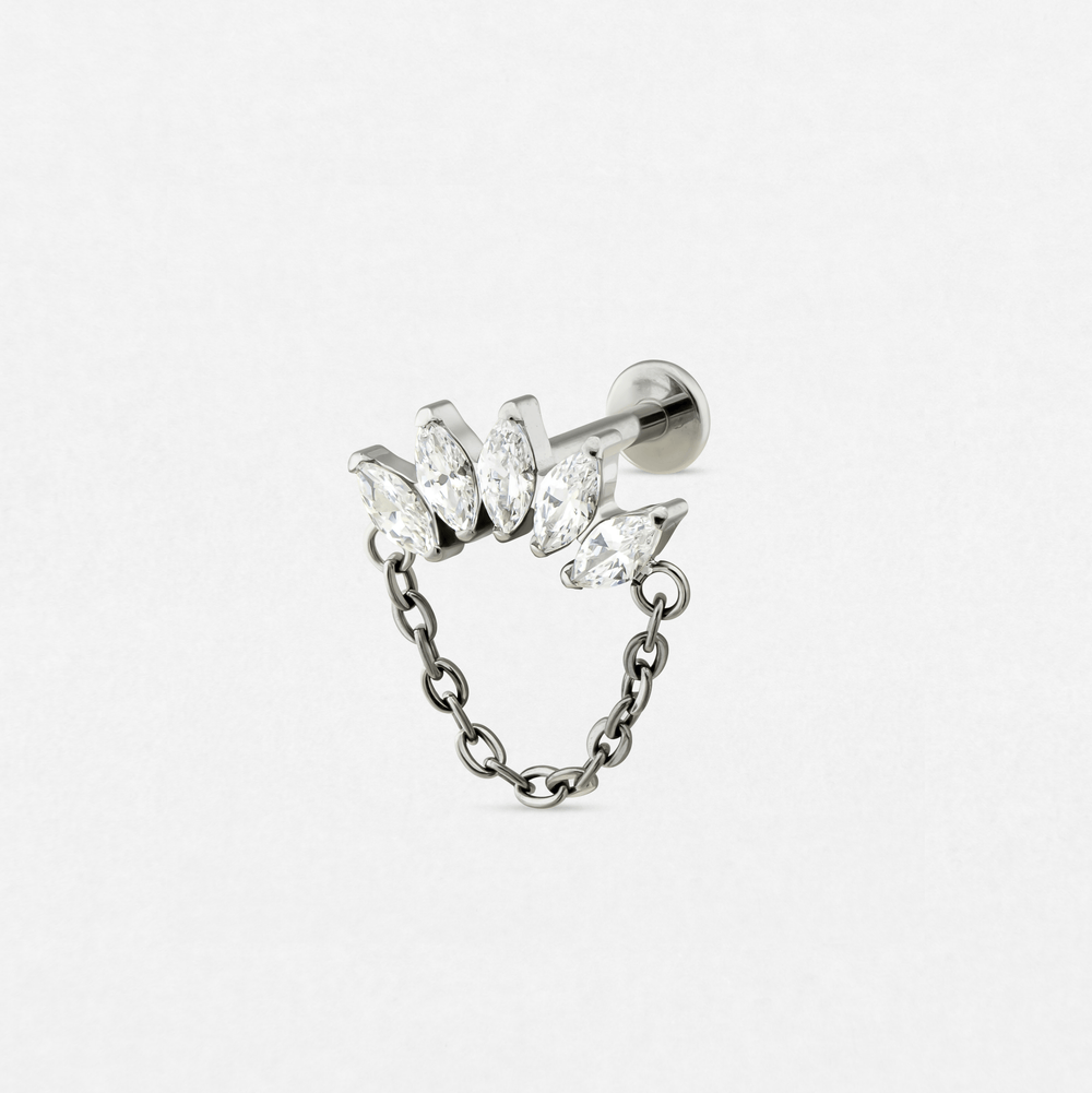 The «Electra» earring by Titanio-Noble Art is a silver stud with five transparent marquise-cut precious stones arranged in a row, attached to a decorative hanging chain, shown on a plain white background.
