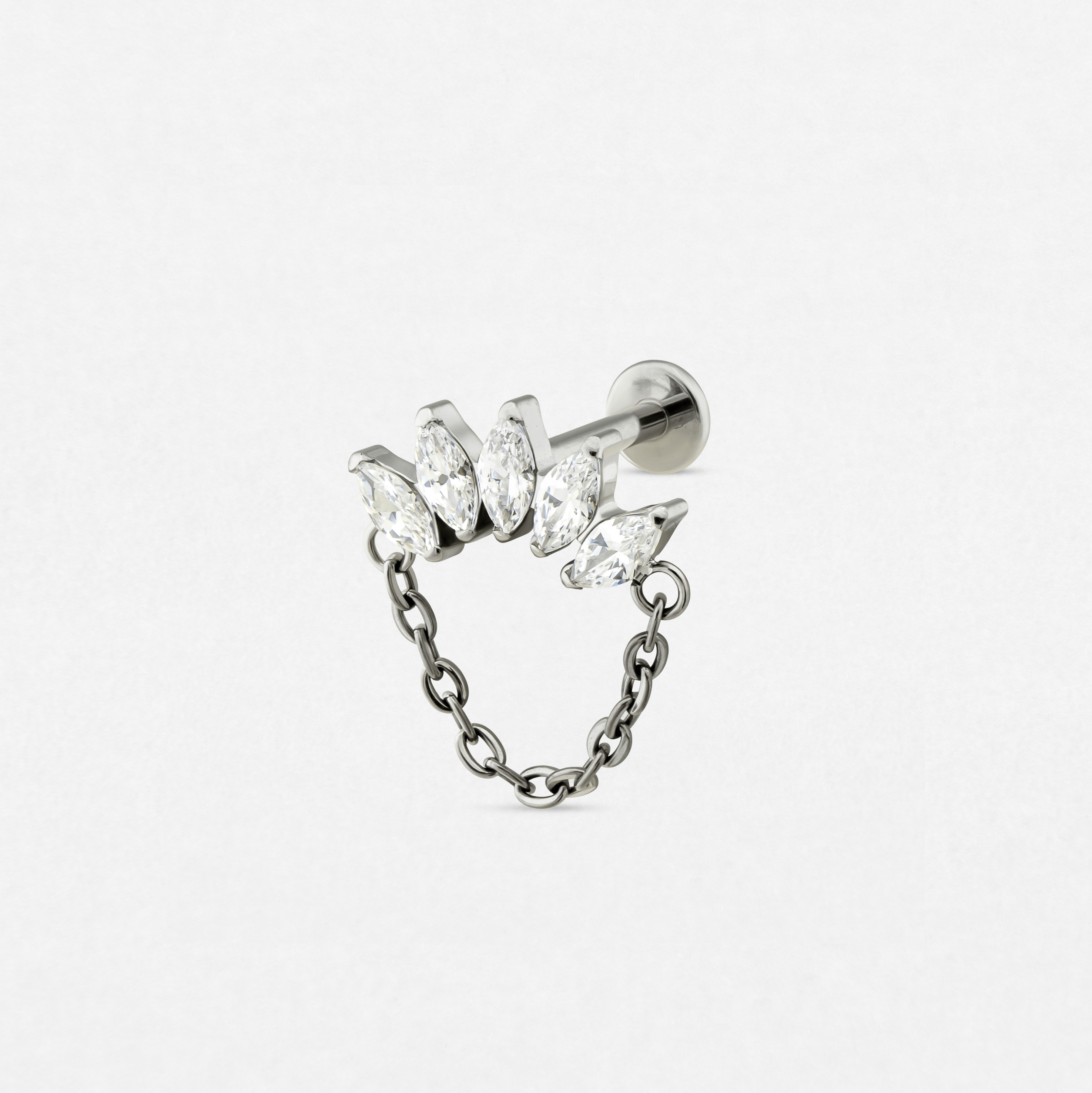 El pendiente «Electra» de Titanio-Noble Art es un pendiente de botón de plata con cinco piedras preciosas transparentes de talla marquesa dispuestas en fila, unidas a una cadena colgante decorativa, que se muestra sobre un fondo blanco liso.
