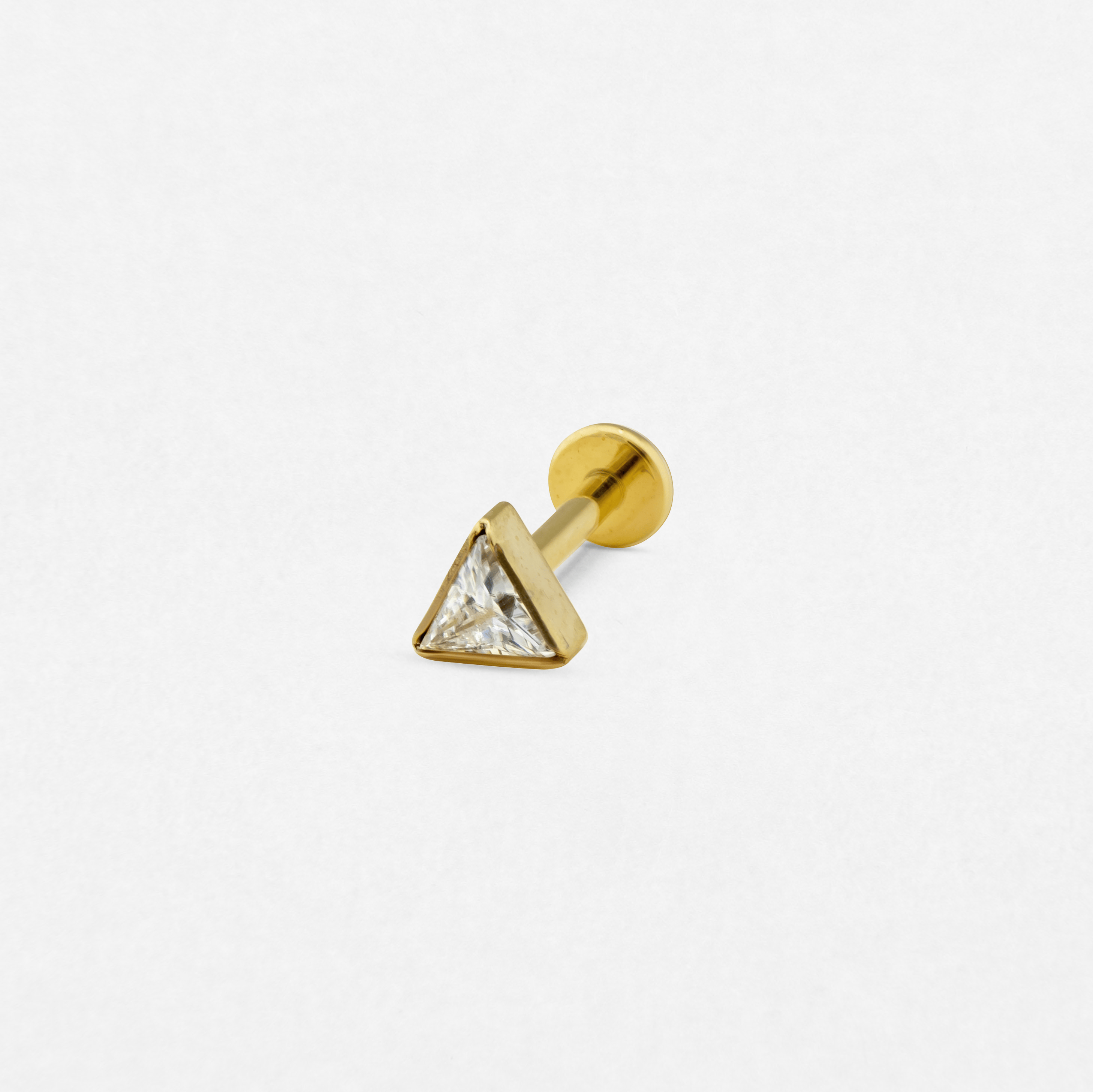 Los pendientes de botón de plata «Titin», de Titanio-Noble Art, cuentan con una montura triangular con una piedra preciosa transparente sobre un fondo blanco, ideales para aportar un toque de estilo sutil tanto si te vas a hacer un nuevo tatuaje como si estás buscando servicios de eliminación láser.