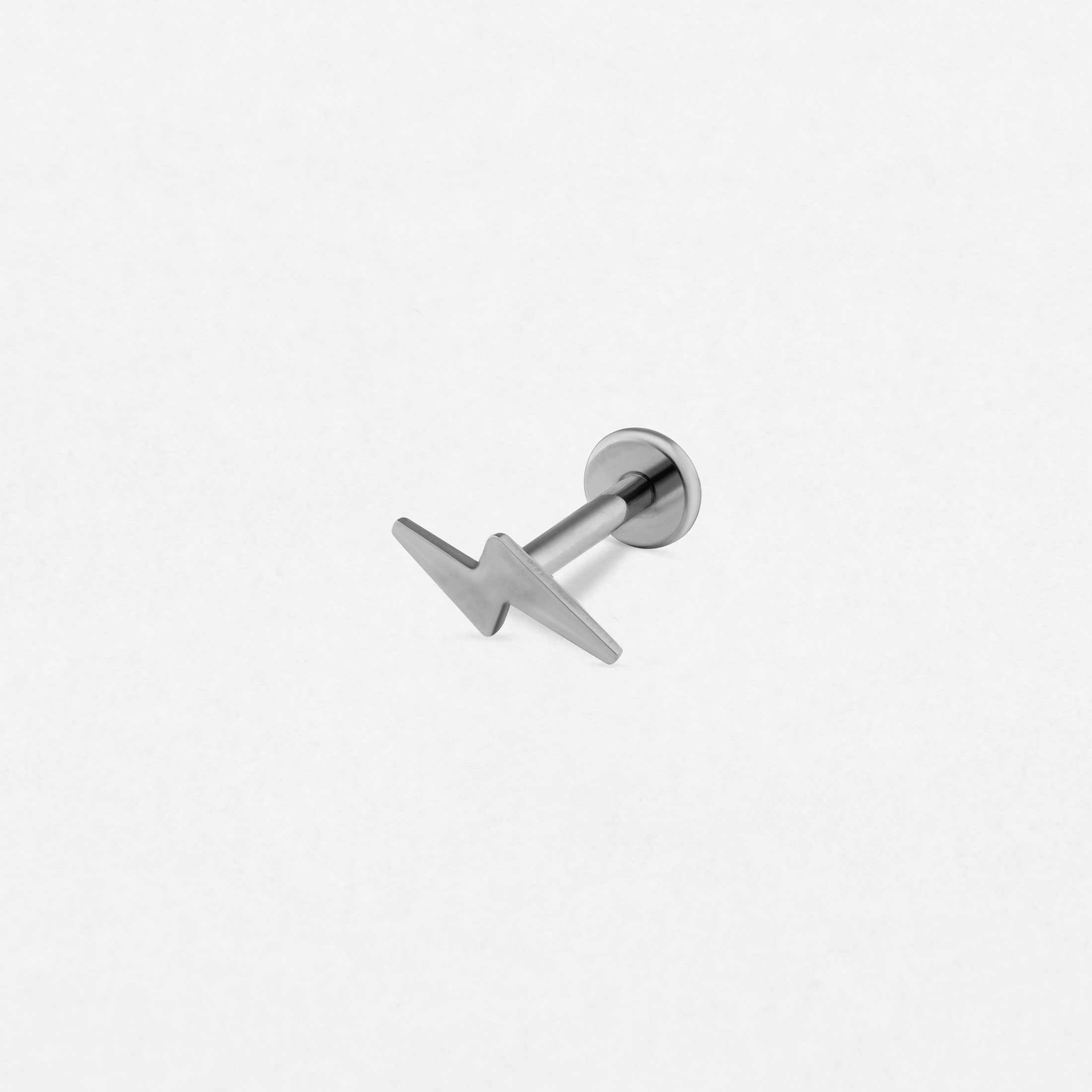 El pendiente «Rayo silver liso» de Titanio-Noble Art presenta un elegante diseño en forma de rayo, ideal para un estilo atrevido o para realzar tu look tras la eliminación de un tatuaje con láser.