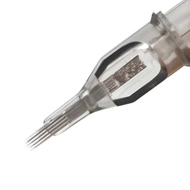 Primer plano del cartucho «Agujas Curved Magnum» de NOBLE ART BEAUTY SOCIEDAD LIMITADA: un cartucho de plástico transparente con agujas finas y muy juntas, imprescindible para los procedimientos de tatuaje y microagujas.